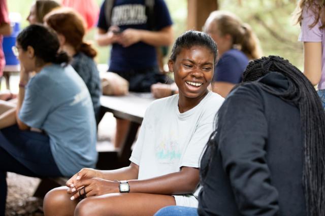 An honors student at the retreat laughs with her friends
