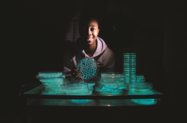 Jada Russell ’20, a biology major, shows off her creation made with Photobacterium leiognathi strain KNH6.