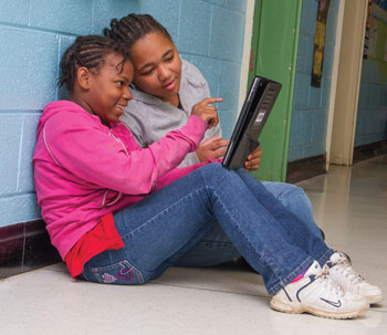 Breaking the boundaries of the traditional classroom, two fifth-graders at Bacon District Elementary School work on a project using an iPad in a quiet hallway
