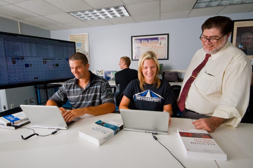 Dr. Glenn Dardick works with students Kenn McIlvaine and Hannah Flaherty in the Longwood Center for Cyber Security. Longwood is the first university in Virginia to be designated a National Center of Digital Forensics Academic Excellence.