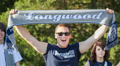 Student holding up a Longwood scarf