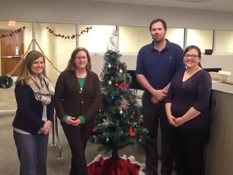 IT Department standing by a Christmas  tree