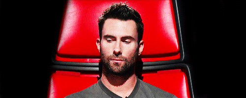 Adam Levine raises eyebrow and makes a face while sitting in The Voice chair