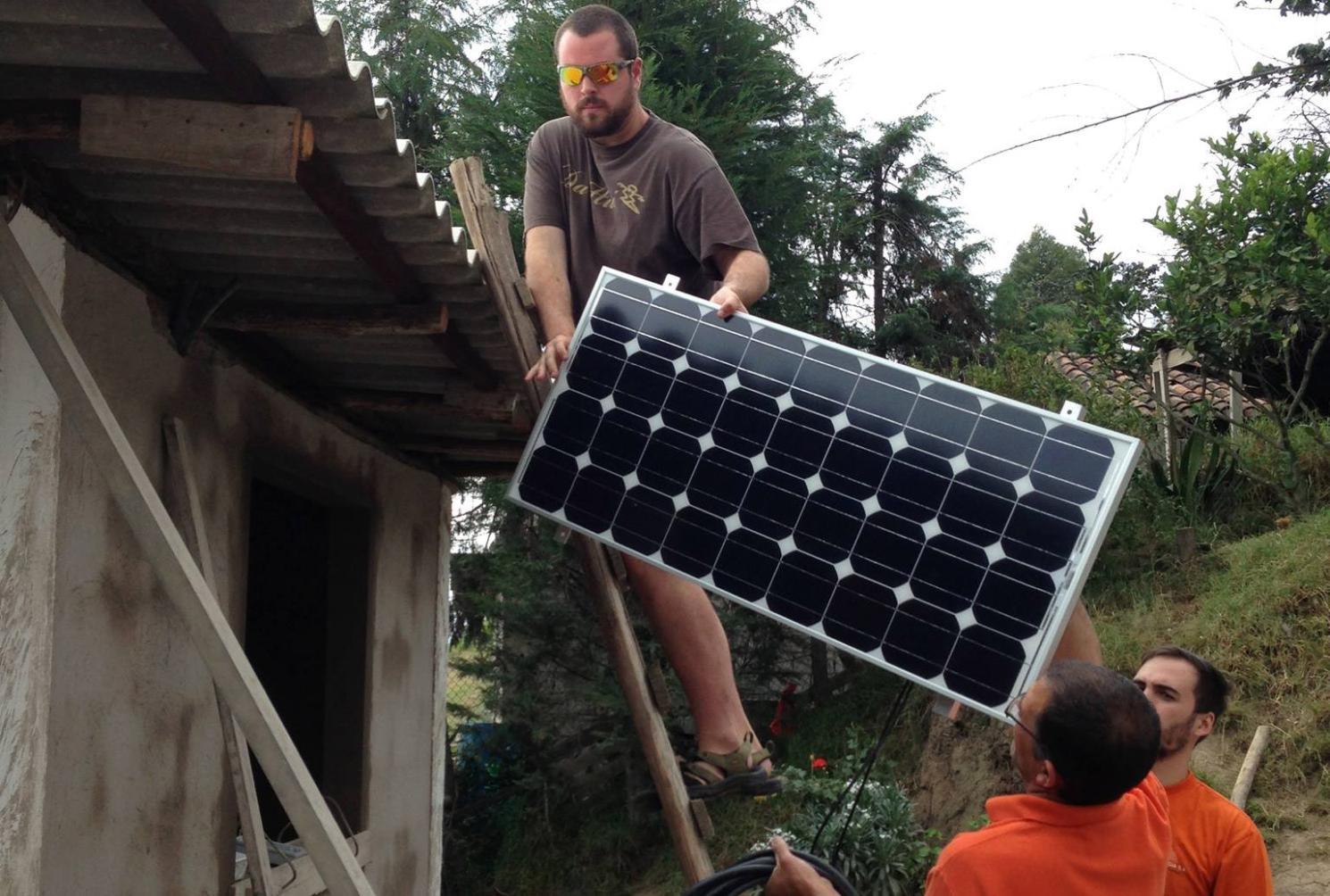 Then-Longwood student Matt Doxey installs a solar panel on a medical clinic during a trip to Ecuador with Dr. Chuck Ross.