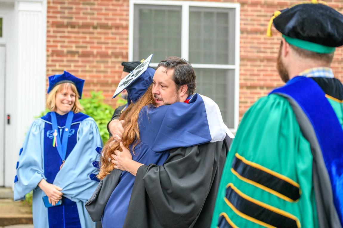 Dr. Halliday hugging a student during Commencement 2018