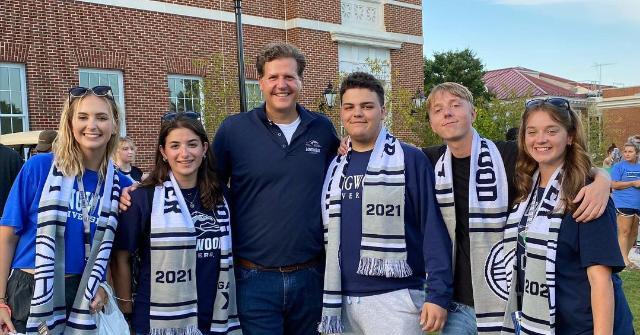 Students wearing their Longwood scarf pose with the President.