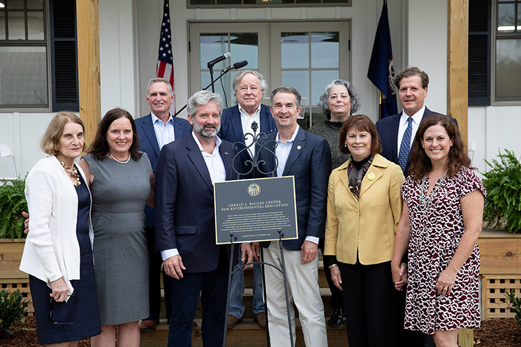 The family of Gov. Jerry Baliles joins Gov. Ralph Northam, President W. Taylor Reveley IV, and other dignitaries around a plaque dedicating the Gerald L. Baliles Center for Environmental Education at Hull Springs.