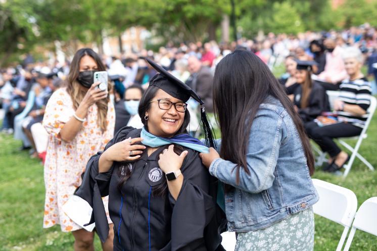 At the graduate ceremony, family members hooded their graduate students.